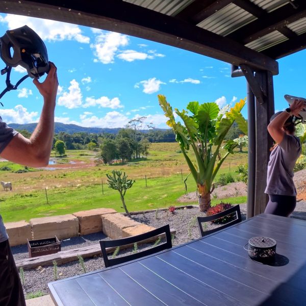 Rider taking off a helmet on the Mayan Farm villa balcony, Kin Kin