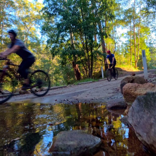 Rider through a rocky creek crossing, Noosa Hinterland mountain biking